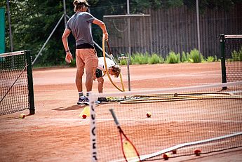 Tennistrainer, Tenniskurse, Tennisschule, Tennistraining Kinder und Jugendliche, Tennis Camps, Vereine, Mannschaftstraining, Einzeltraining, Gruppenkurse, BTV Trainer B-Lizenz Wettkampf in Kempten und im gesamten Allgäu. Ein Junge mit einer Dusche am Tennisplatz beim Tenniscamp im Allgäu.
