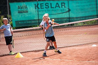 Tennistrainer, Tenniskurse, Tennisschule, Tennistraining für Kids, Kinder und Jugendliche, Tennis Camps, Vereine, Mannschaftstraining, Einzeltraining, Gruppenkurse, BTV Trainer B-Lizenz Wettkampf in Kempten und im gesamten Allgäu. Junge beim Tennisschlag auf dem Tennisplatz mit Tennistrainer in einer Trainerstunde und einer Gruppe beim lernen von Tennistechnik.