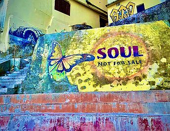 Yogalehrer, Typberatung nach Ayurveda, Thai Vedic, Dosha Test, Ernährung Coach, Ernährung nach den 5 Elementen, Ayurveda, ayurvedische Ernährung Routine, Thai Yoga Massage, Thaiyogamassage, Yogakurs, Yoga Klassen, Yoga Personal Training. Eine Ayurveda und Yoga Schule mit Lehrer und Trainer aus dem Allgäu in Indien vor einer Treppe mit Lehrtafeln für Wissen und lernen im Personal Training.