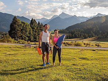 Personal Trainer Allgäu, Outdoor Guide, itness, Schmerztherapie, Rezeptoren Schmerz, Figurtraining, Physio. Ein Mann in den Allgäuer Alpen als Personal Trainer beim trainieren mit einer Frau in der Natur bei outdoor Aktivität an Physio Übungen für Schmerz, Therapie, Linderung und Gesundheit bei gutem Wetter.