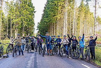 E-Bikeguide, E-MTB Guide, geführte Fahrradtouren im Allgäu, Techniklehrer, Fitnesstrainer, Funktionelles Training, Thai Yoga Massage, Ayurveda Eine Bikegruppe im Wald bei einer Fahrradtour mit Bikeguide bei einer Pause mit Fotostopp vor der Technikschule MTB Mountainbike